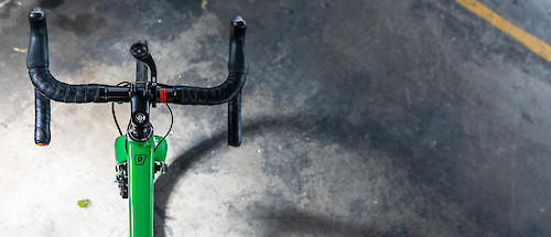A green road bicycle, viewed from above.