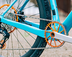 Drivetrain detail of Garbaruk bicycle components in orange, fitted to a carbon Gothic Cycles gravel bike