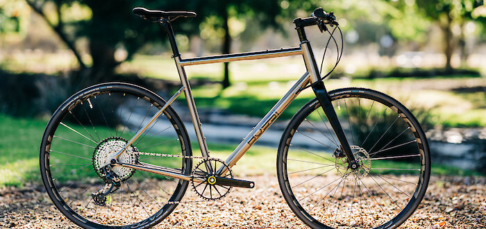 A titanium Bossi Grit gravel bike, custom-built into a flat-bar commuter